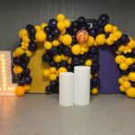 Balloon arch with basketball and lit number.